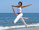 Healthy Woman Jumping for Joy on the Beach